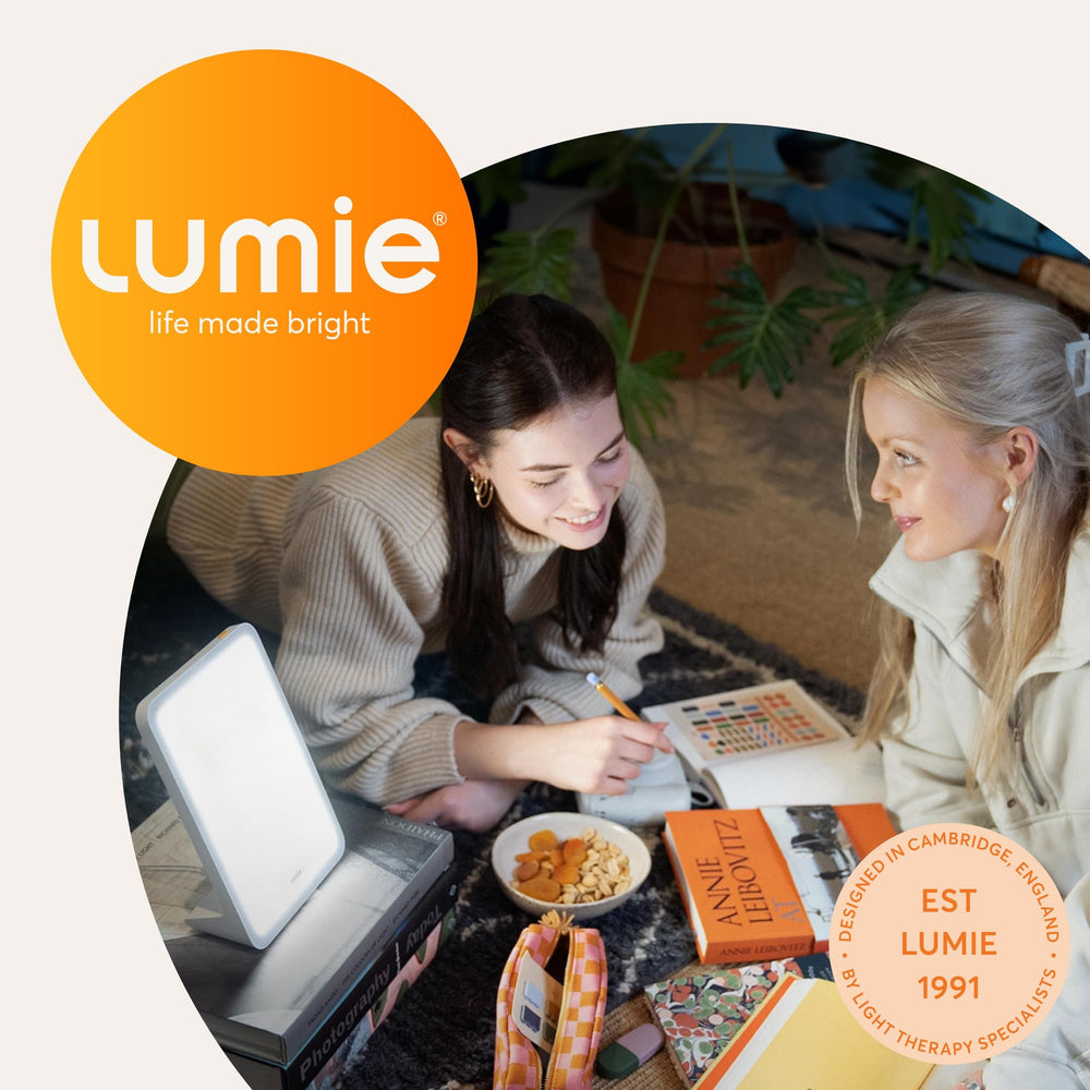 Lumie Mini Lamp positioned beside a laptop for workspace lighting