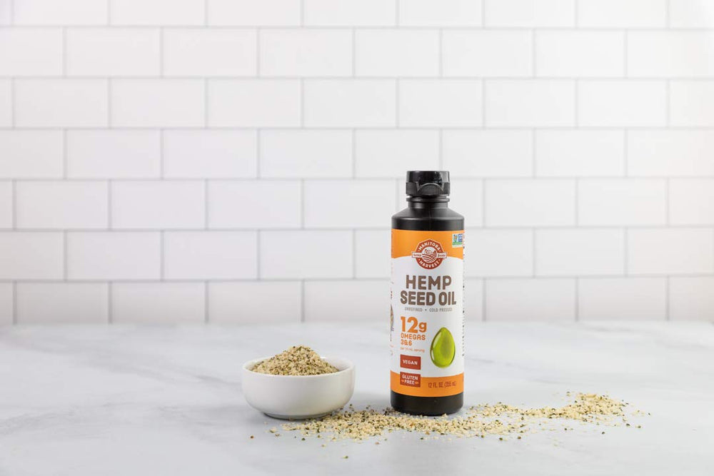 Clear glass bottle of Manitoba Harvest hemp seed oil on a pantry shelf.
