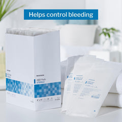 Box of McKesson 24-count ABD pads emphasizes absorbent drainage management for abdominal wounds.