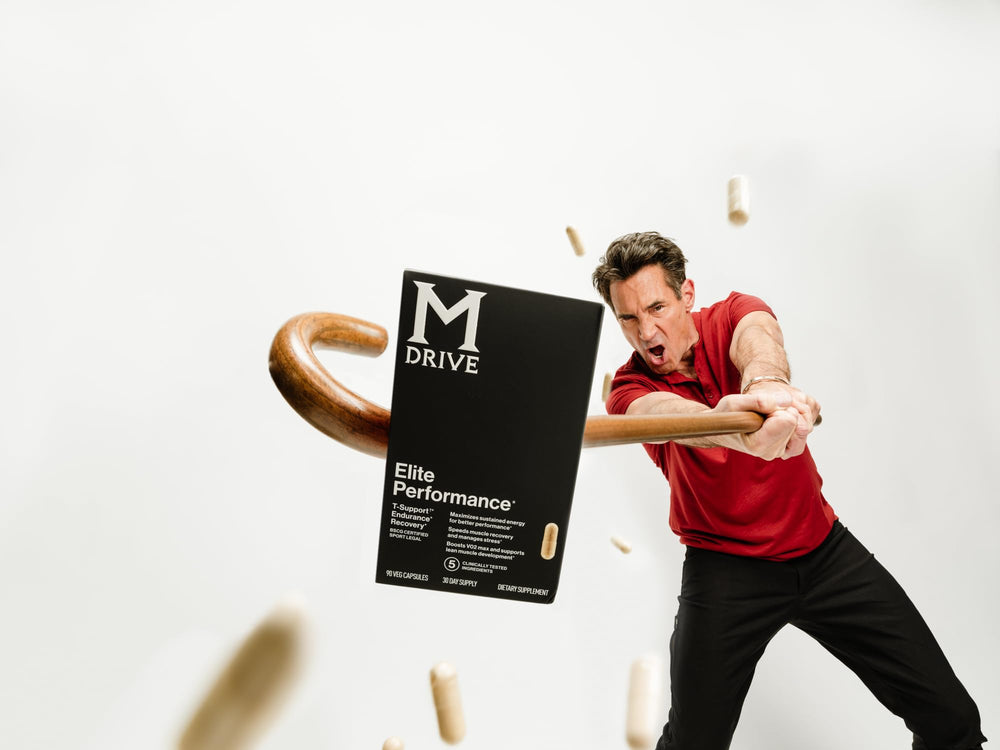 Mdrive Elite bottle beside glass in bright, healthy lifestyle setting.