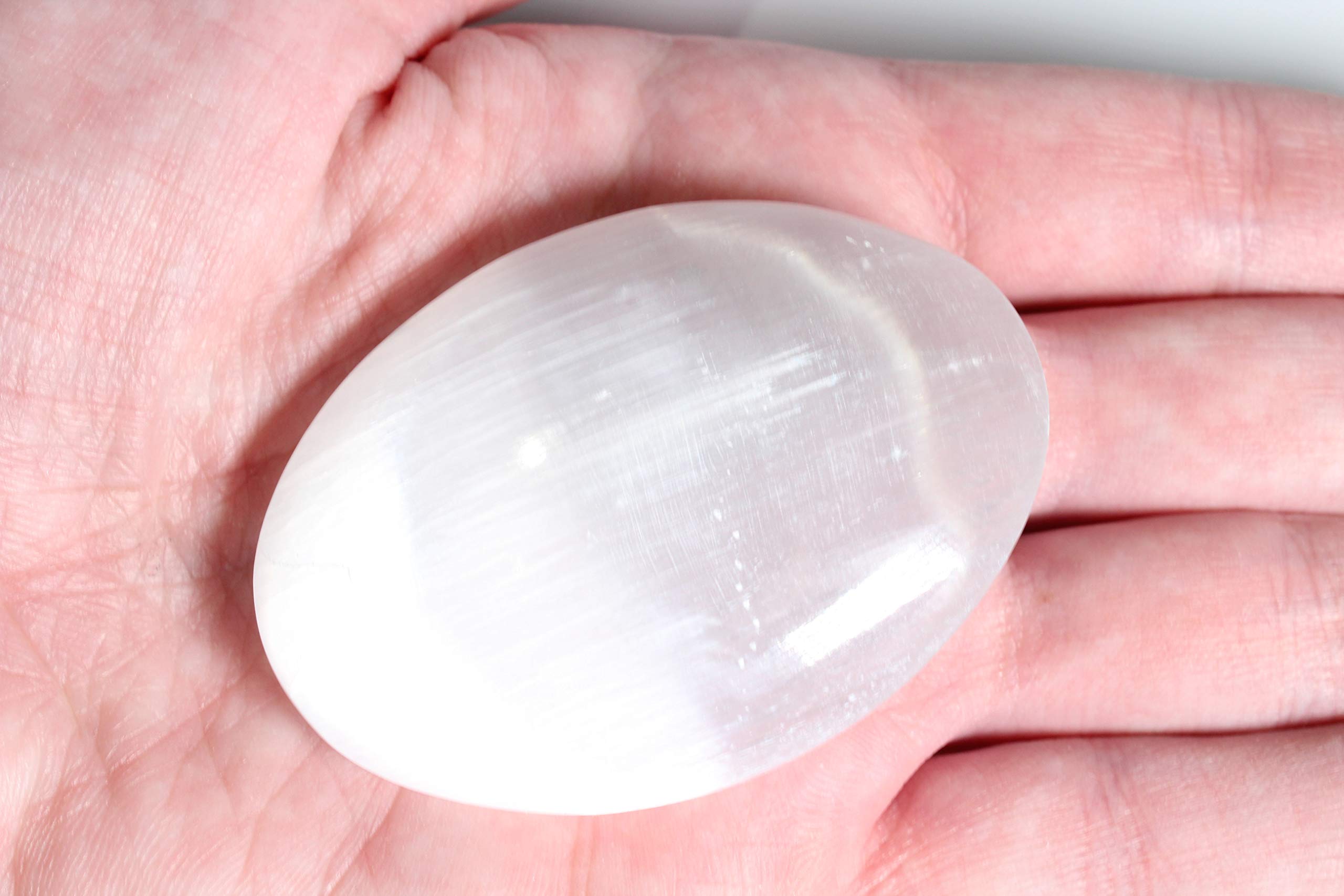 MINERALUNIVERSE white selenite crystal palm stone on desk setup.