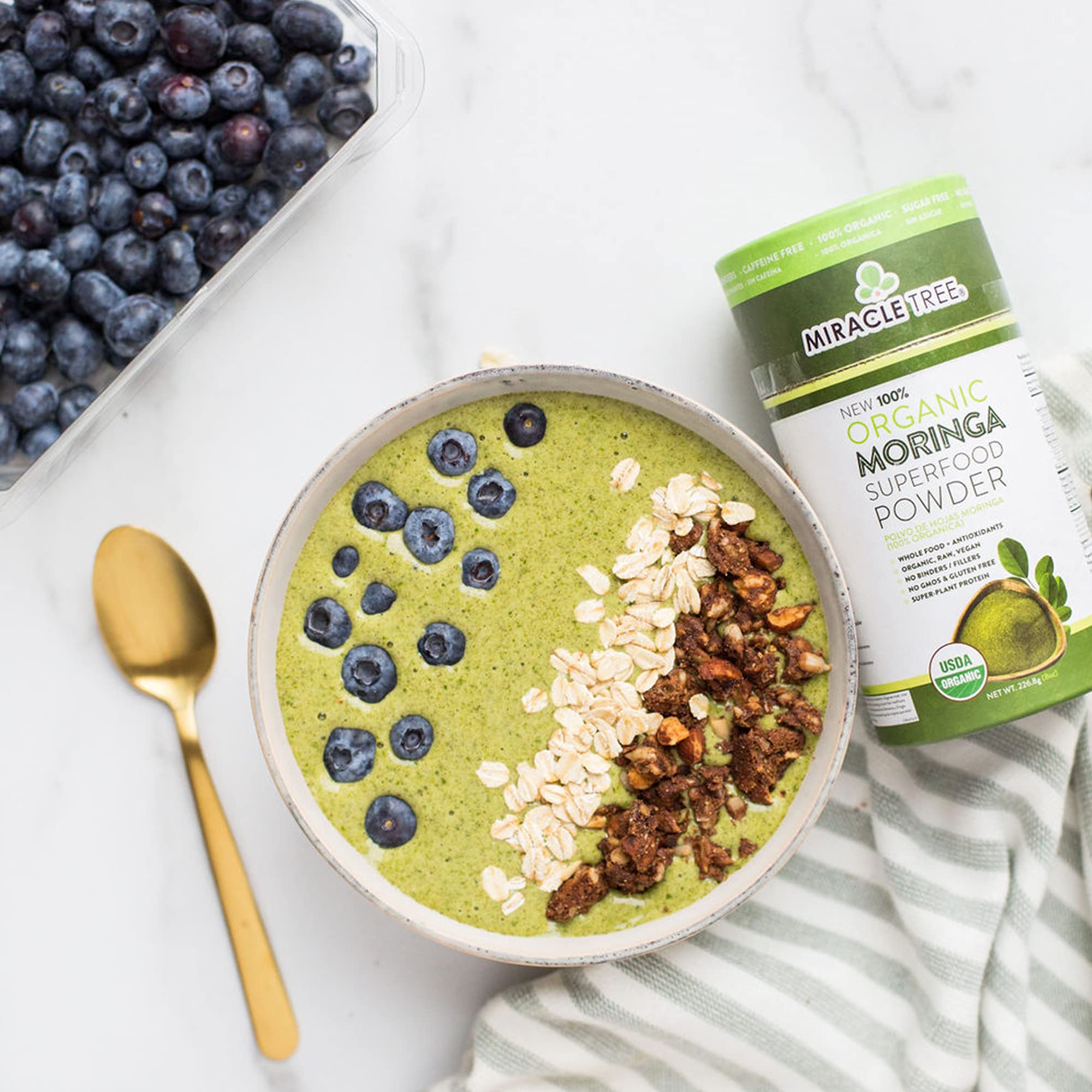 Miracle Tree moringa powder in a bowl suggesting smoothie or yogurt uses.