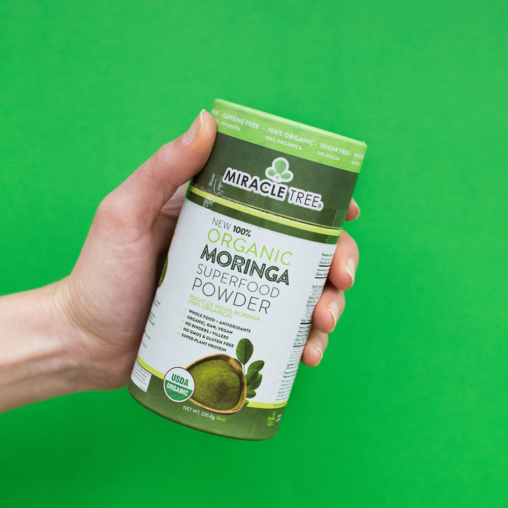 Miracle Tree moringa powder with a steaming cup for warm rituals.