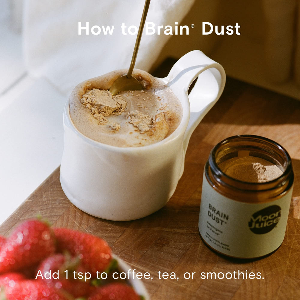 Moon Juice Brain Dust glass with drink demonstrating caffeine-free cognitive support.