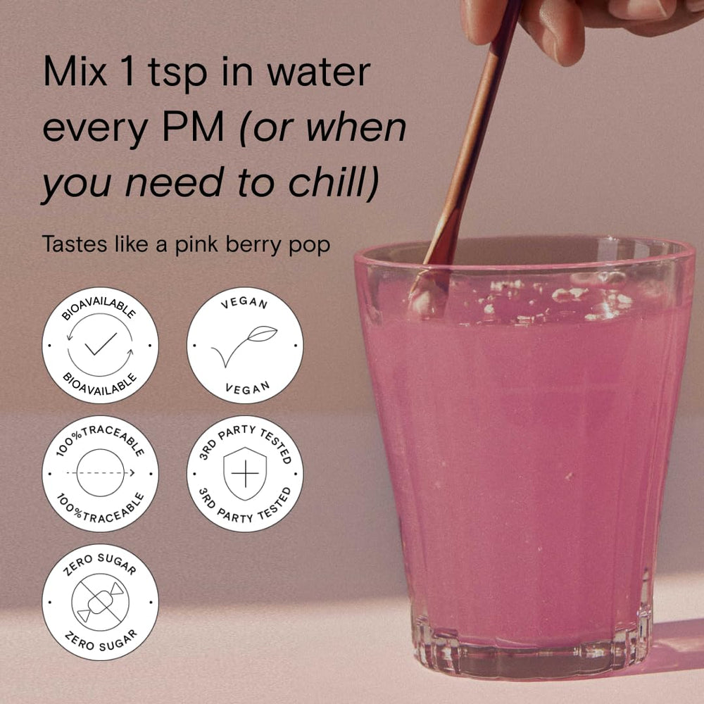 Moon Juice Magnesi-Om Berry Blue Lemon stick with a meditation candle for evening routine.