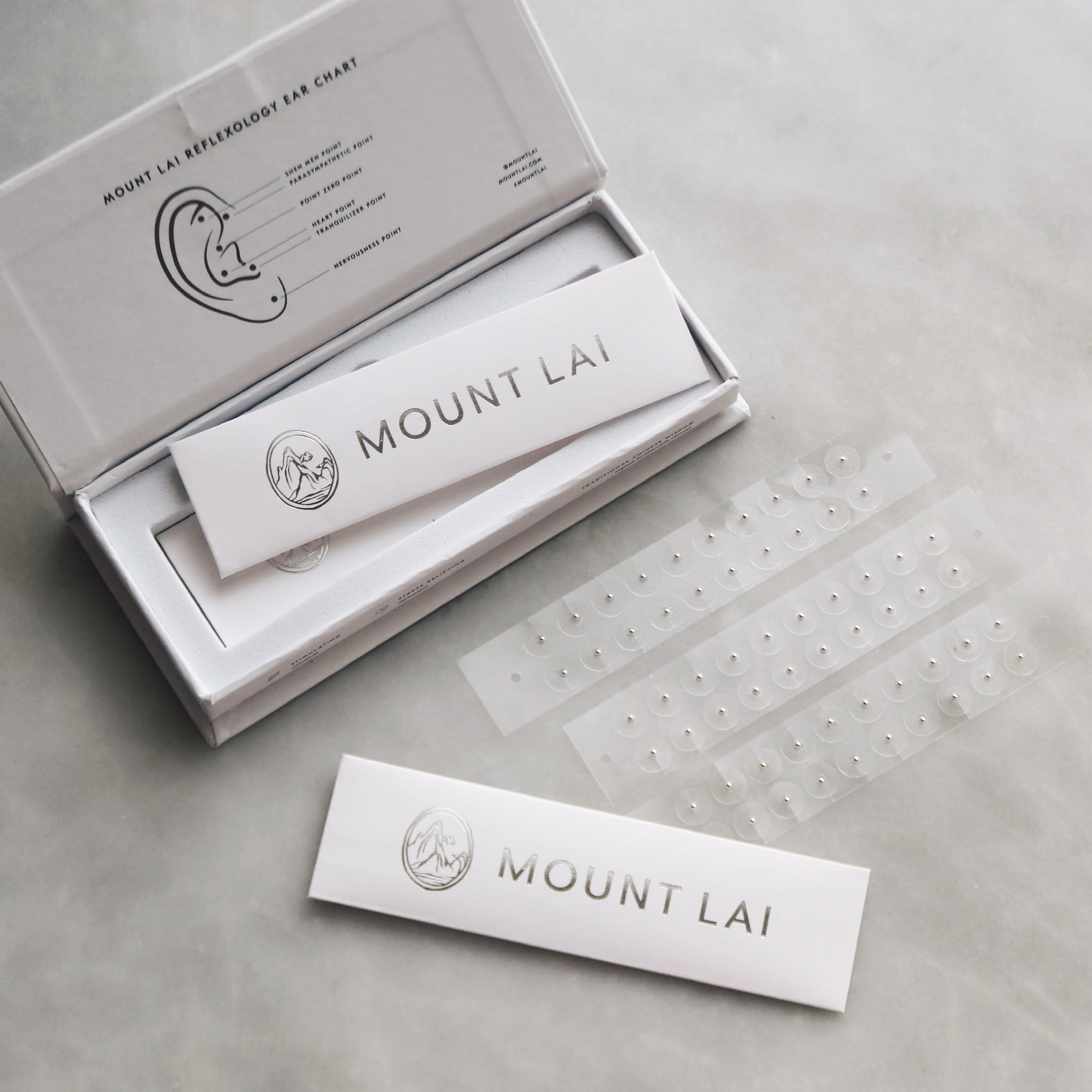 Applying Mount Lai ear seed to the ear for needle-free pressure