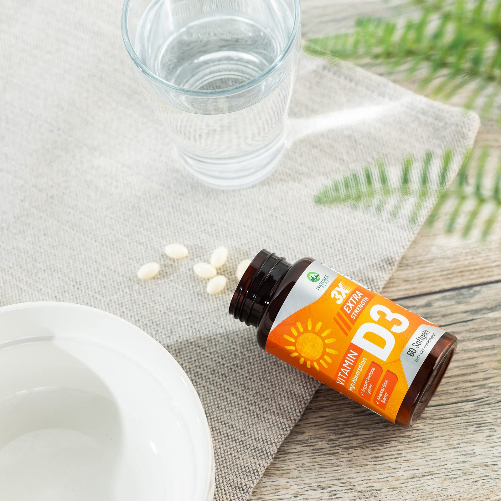 Hand holding Nature's Peak D3 5000 IU softgels for quick intake