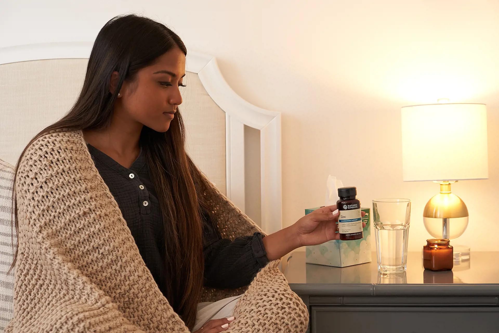Nature's Sunshine Zinc 25mg bottle with a glass of water for easy daily use