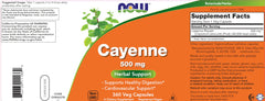 NOW Cayenne capsules on kitchen counter beside peppers, ready for spice-inspired routine.