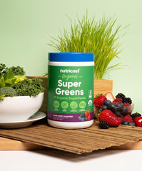 Nutricost Super Greens scoop beside the mixed berry powder, emphasizing fiber-rich daily use.