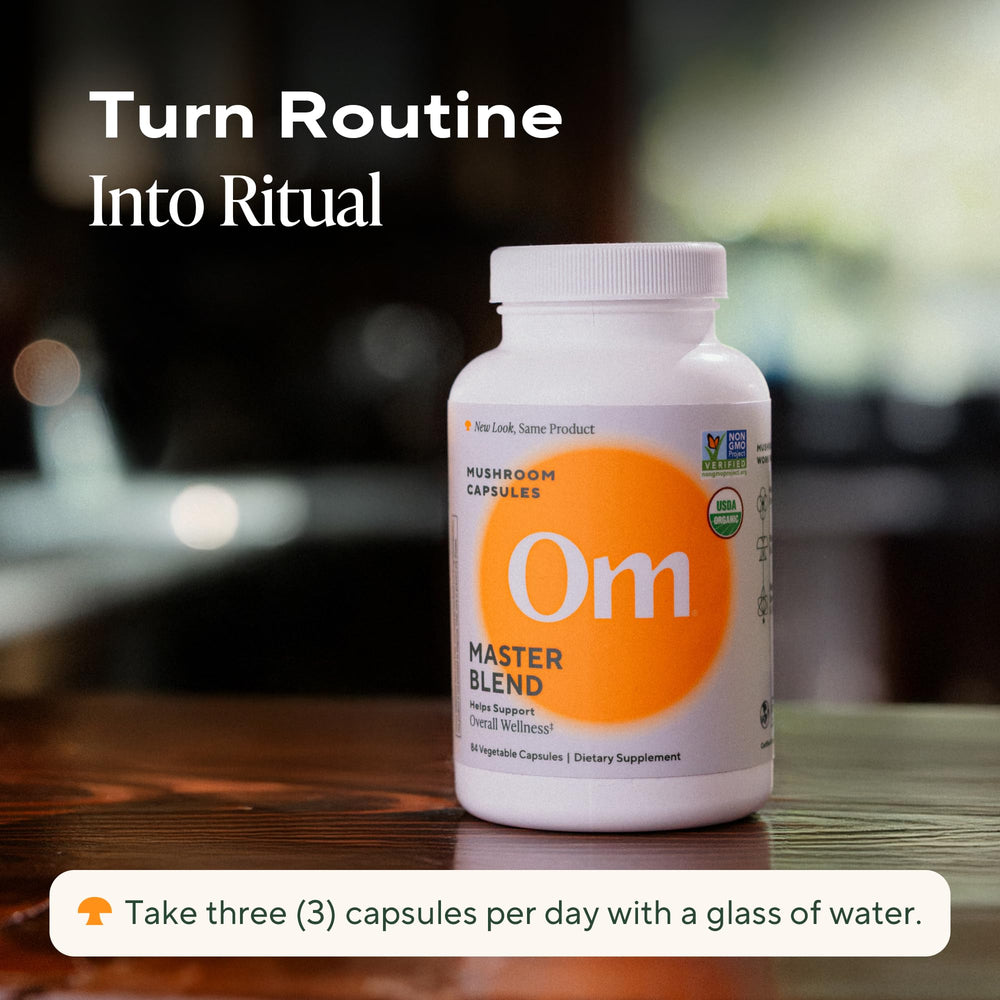 OM Master Blend bottle with glass beside water for easy daily routine.