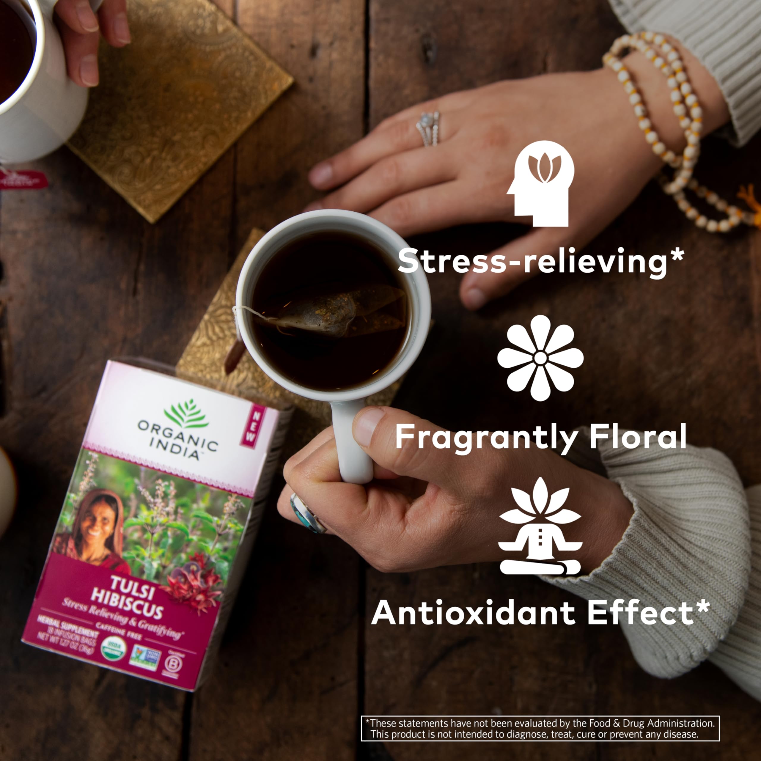 Pouring hot water into a mug reveals vibrant hibiscus and tulsi infusion.
