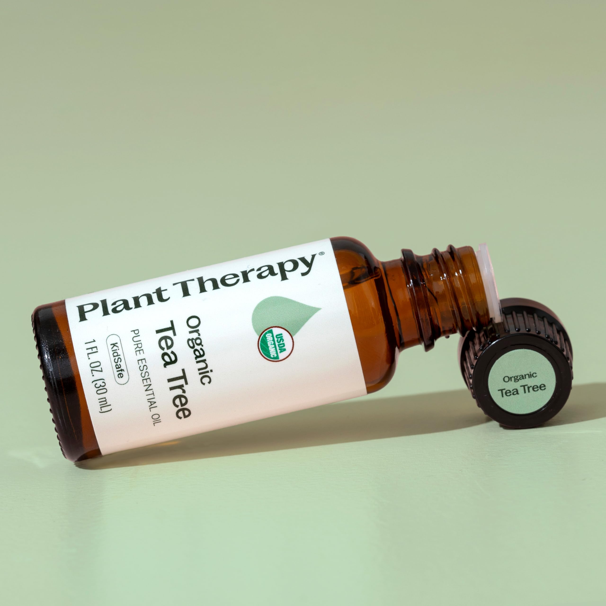 Plant Therapy Tea Tree Oil in hand ready for dilution before topical use