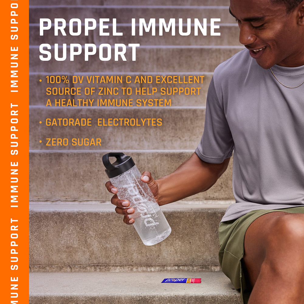Propel Immune Support Powder Lemon Blackberry scoop resting beside a prepared drink.