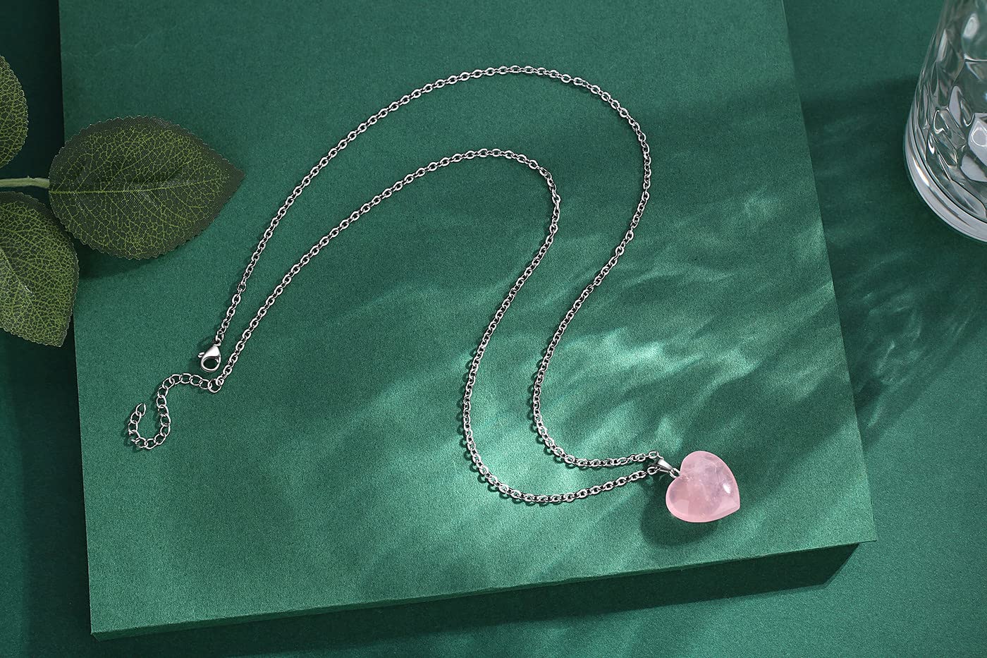 QINJIEJIE Rose Quartz Heart pendant in hand, portable energy for calm.