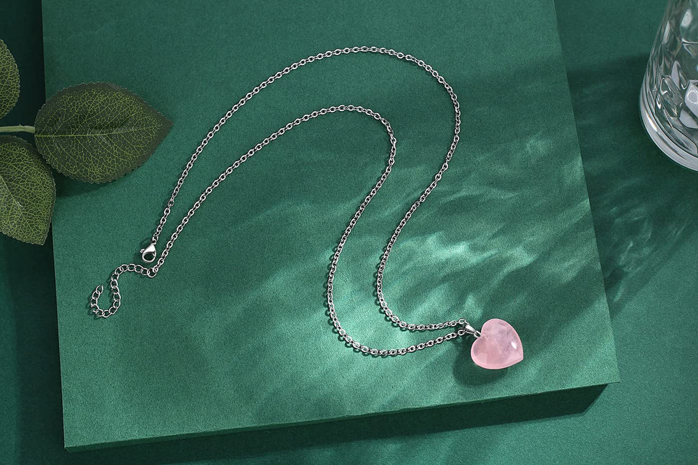 QINJIEJIE Rose Quartz Heart pendant in hand, portable energy for calm.