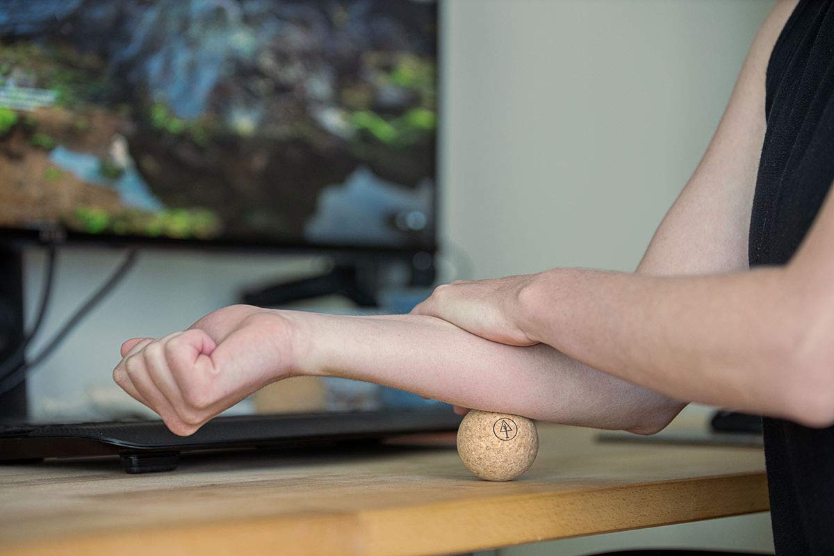 Rawlogy compact massage ball held in hand for targeted release