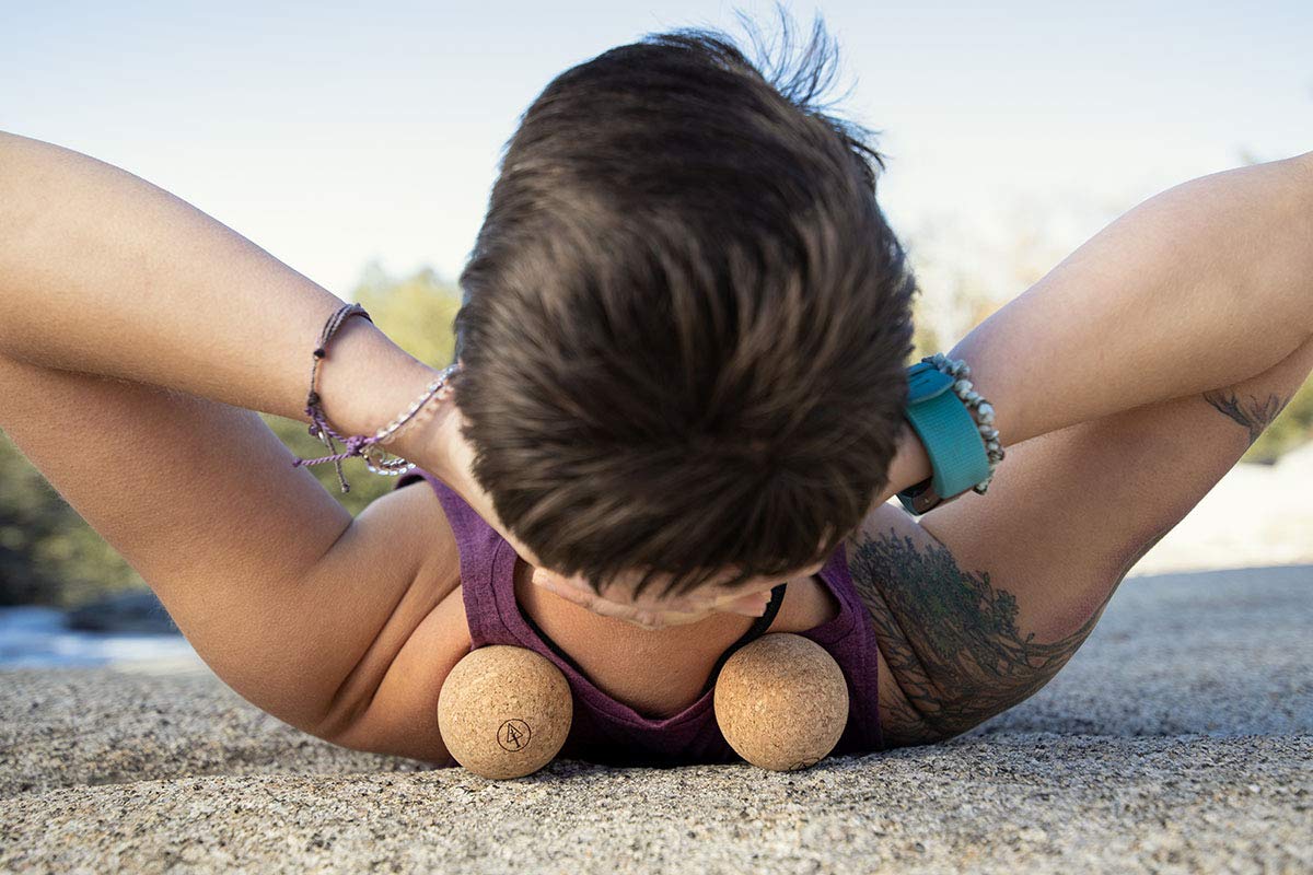 Rawlogy cork massage ball held in hand for precise self-massage on tight spots.