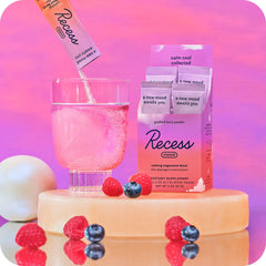 Scoop of Recess Mood Powder gradient berry beside bottle for quick mixing