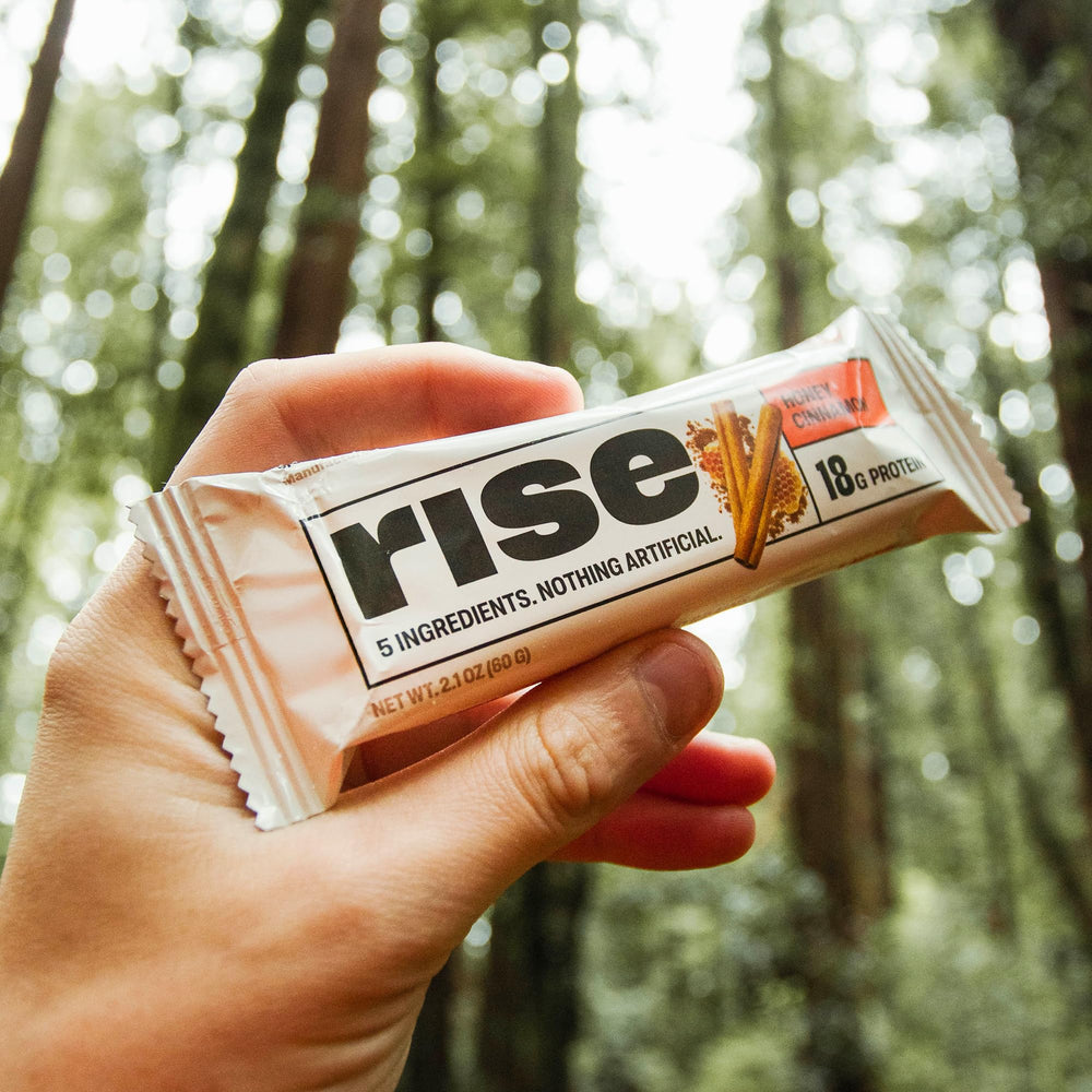 Rise honey cinnamon whey bar texture close-up showing natural ingredients.