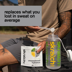 Dissolving Skratch Labs unsweetened hydration powder in a glass of water.
