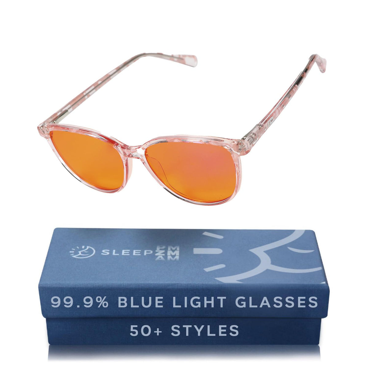Sleep ZM Pink Warrior amber-lens glasses on desk reduce blue light for late-night work.