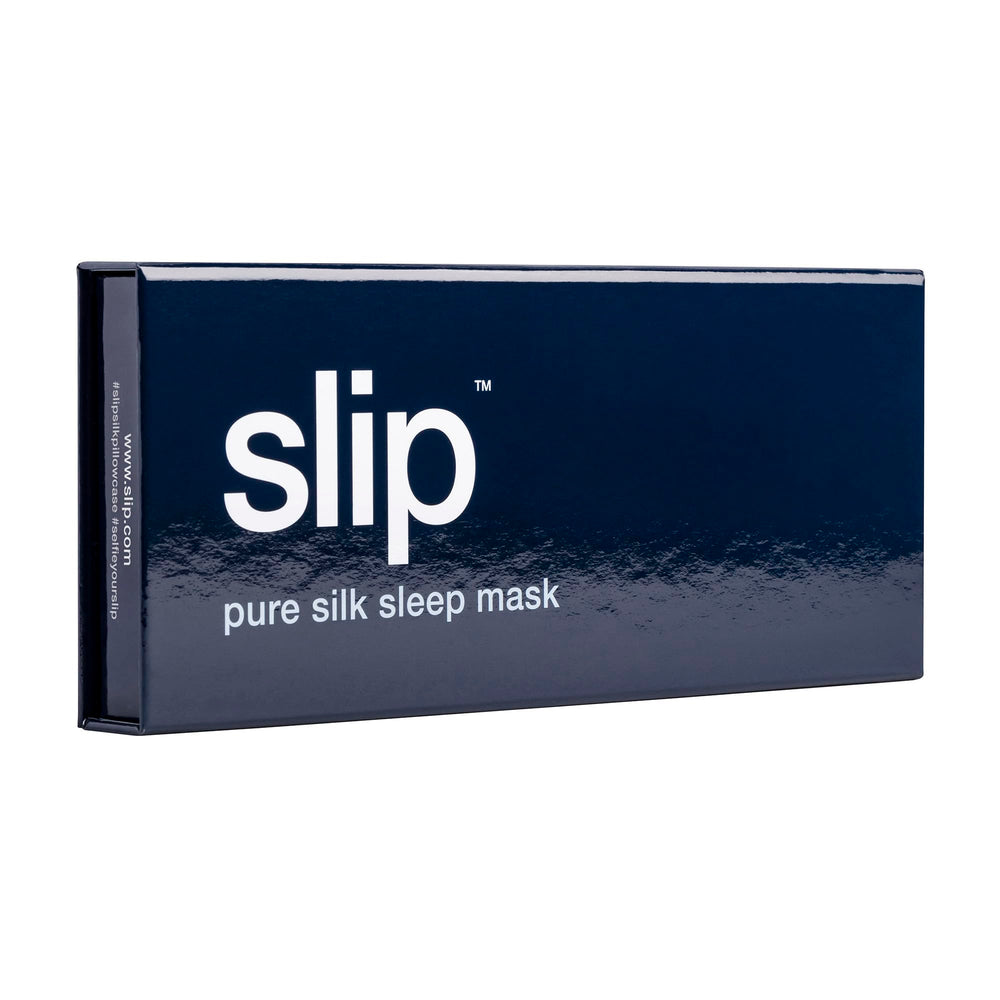 SLIP Pure Silk Sleep Mask Navy on a bedside surface highlighting hair-friendly design.