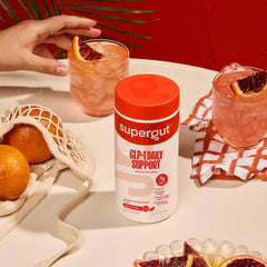 Supergut GLP-1 Daily Support glass of mixed drink with ice and citrus.
