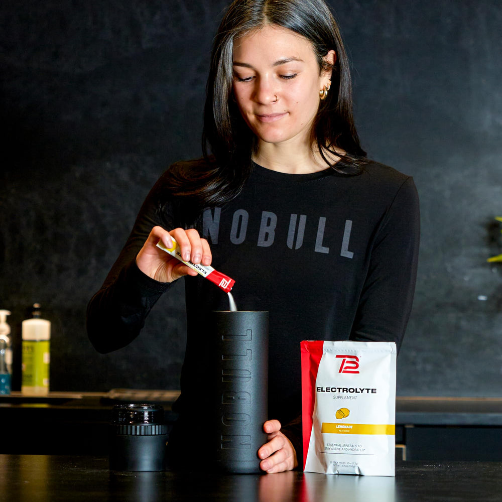 TB12 Electrolytes lemonade dissolved in water showing a clear, refreshing hydration option.