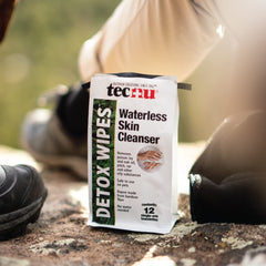 Tecnu Detox Wipes used in outdoor setting for hiking skin cleansing.