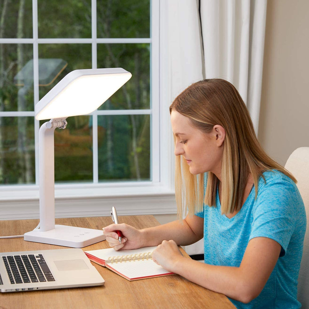 Theralite Aura Bright lamp on a home office desk providing daylight-like illumination