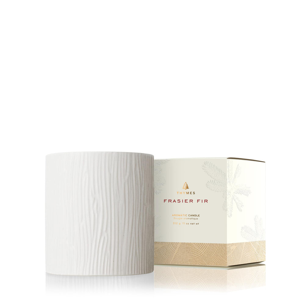 Thymes Frasier Fir candle in wood-grain ceramic creates cozy ambience.