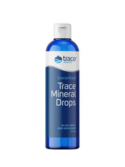 Trace Minerals Concentrace mineral drops bottle beside a glass of water for daily mineral support.
