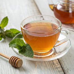 Uncle Lee's Senna Tea cup with hot brew highlights caffeine-free herbal blend.