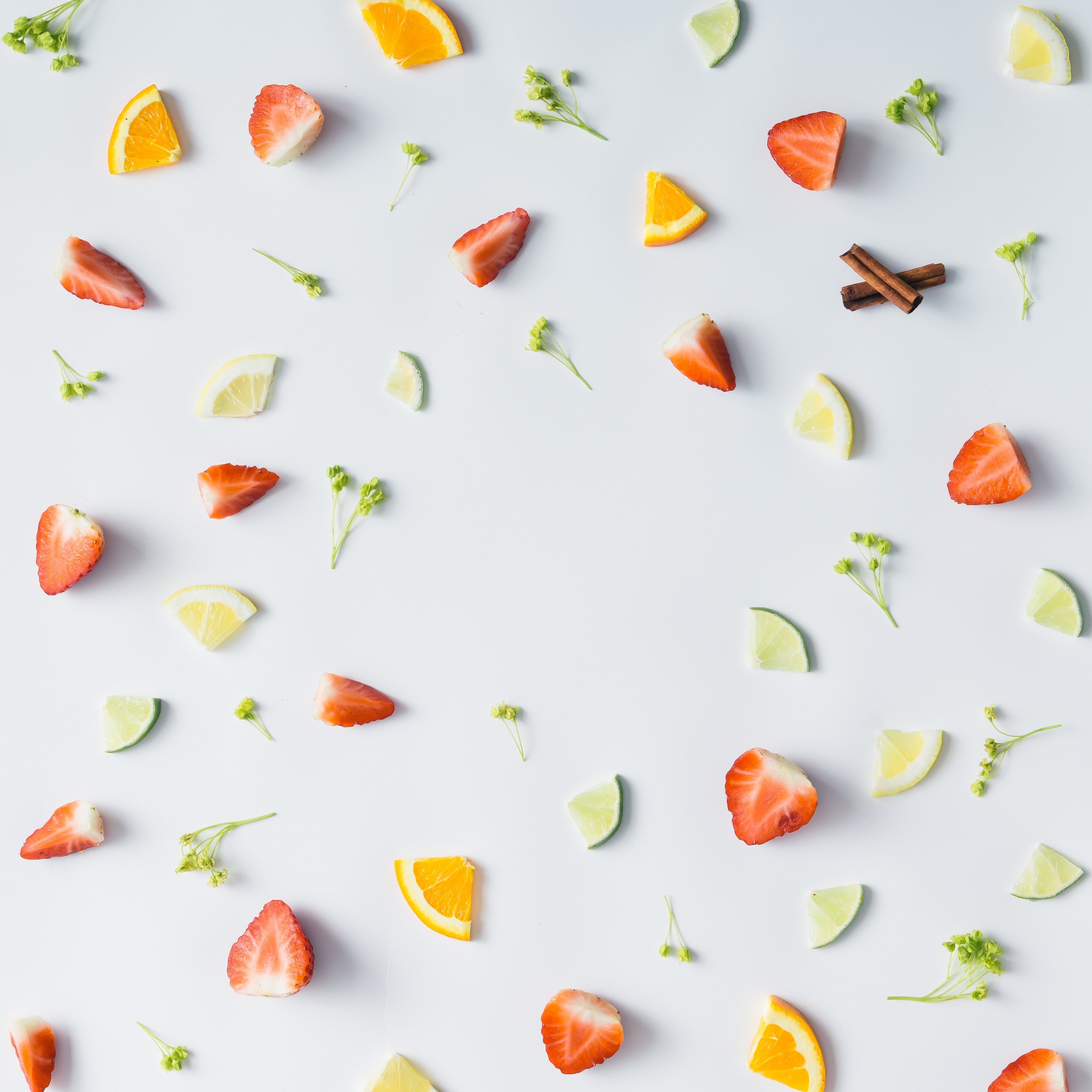 Fruit slices including strawberries, oranges, and lemons on a light gray background
