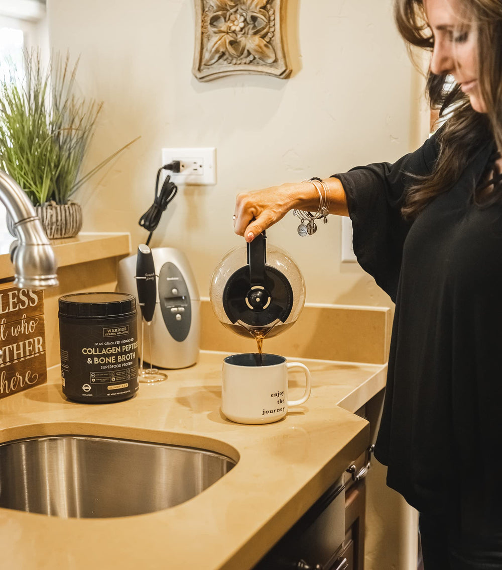 Warrior Strong Wellness packaging on countertop with measuring scoop.