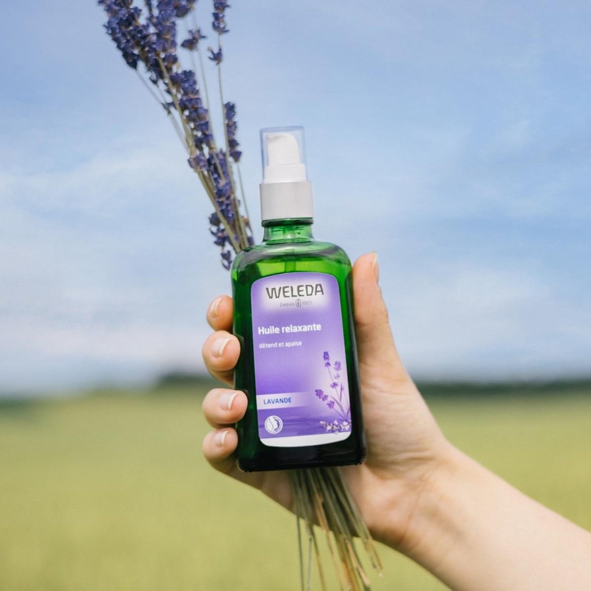 Hands applying Weleda lavender oil for a relaxing massage.