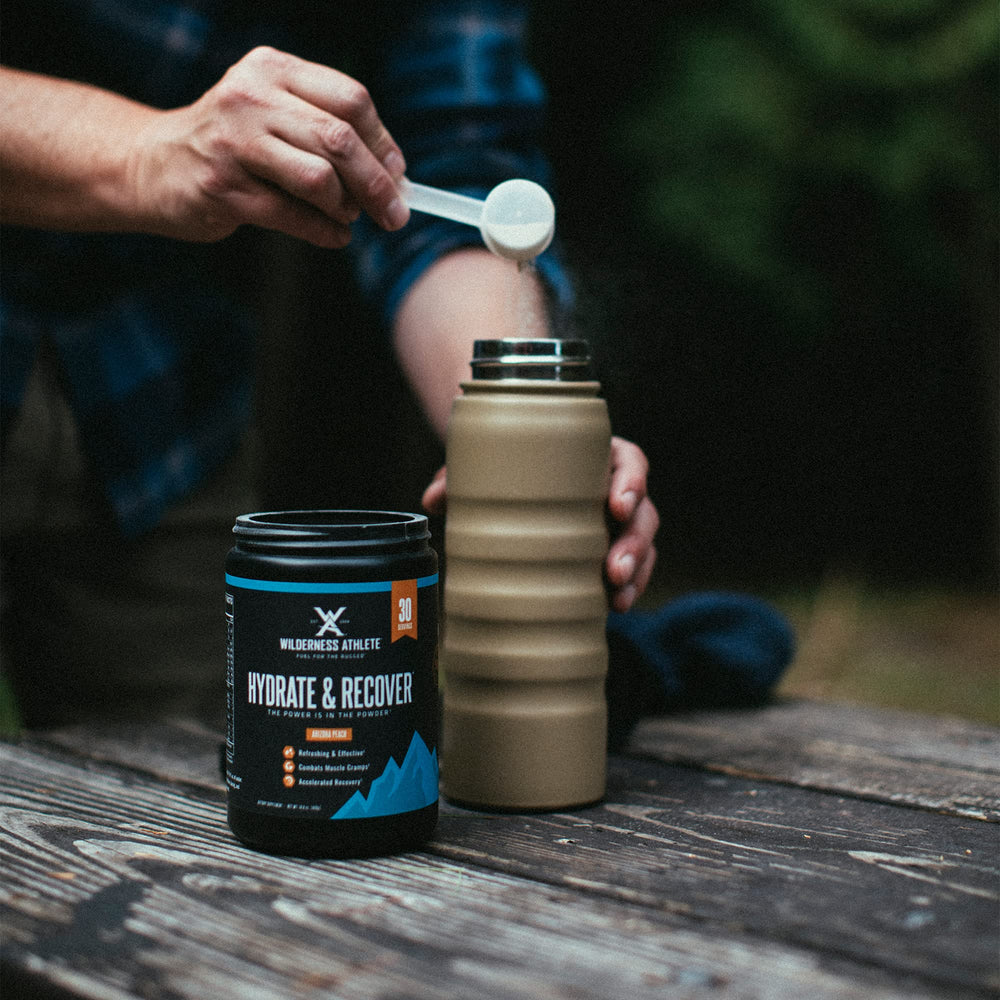 Wilderness Athlete mixed hydration drink in glass with blue raspberry flavor.