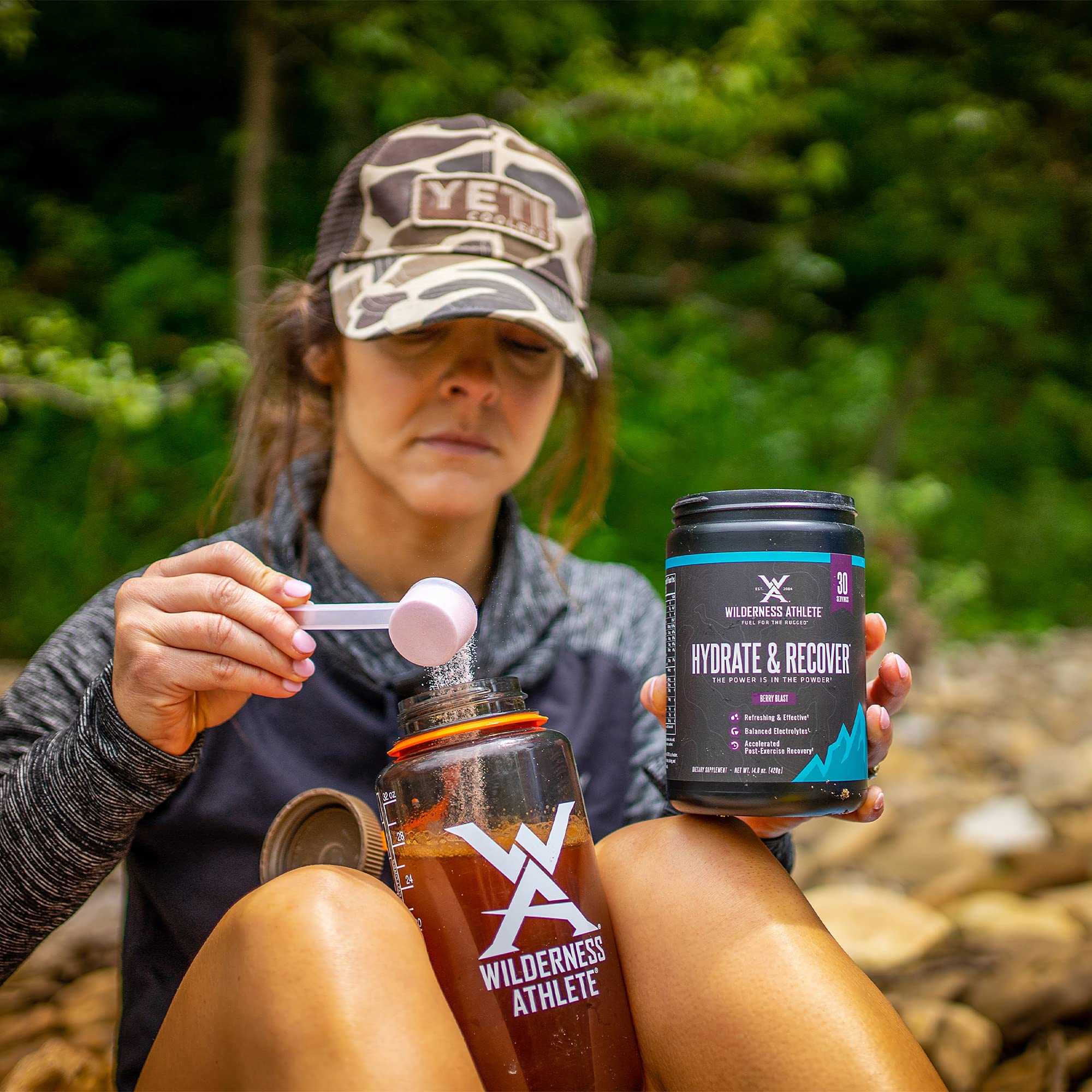 Wilderness Athlete scoop with blue raspberry powder ready to mix.